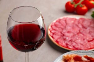 Copa de vino italiano junto a mesa de entrantes
